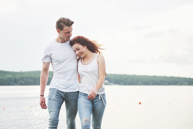 Feliz pareja joven disfrutando de una playa solitaria