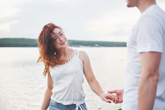 Feliz pareja joven disfrutando de una playa solitaria