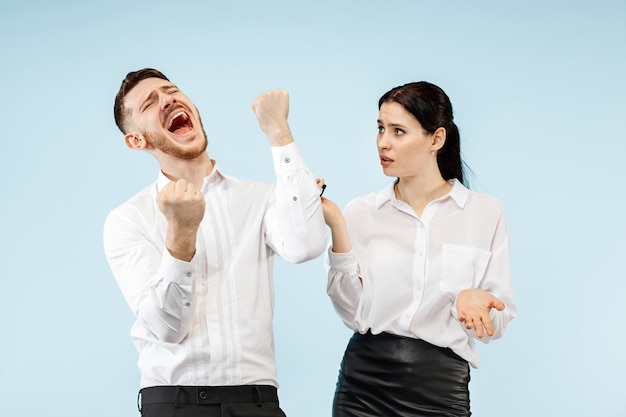 Feliz pareja joven emocionada mirando a la cámara con deleite