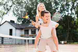 Foto gratuita feliz pareja joven jugando tenis