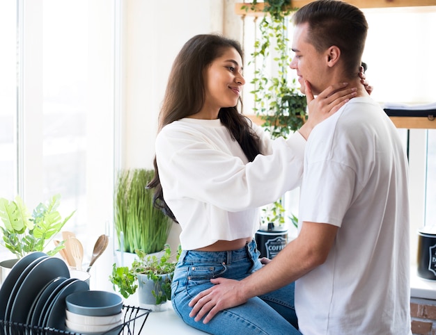 Feliz pareja joven multirracial de amantes acariciando en cocina