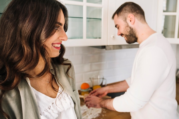 Feliz pareja joven parado en la cocina