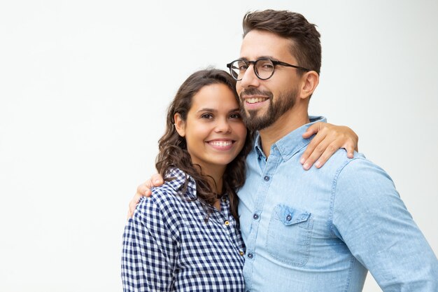 Feliz pareja joven de pie y abrazando