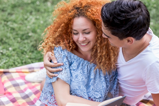 Feliz pareja joven sonriente abrazando en un parque