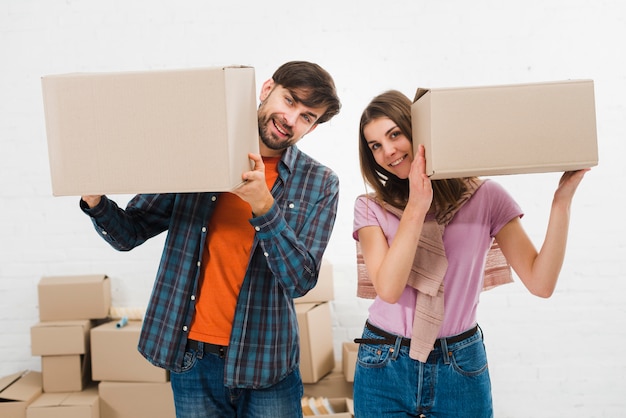 Feliz pareja joven sosteniendo las cajas de cartón en la mano