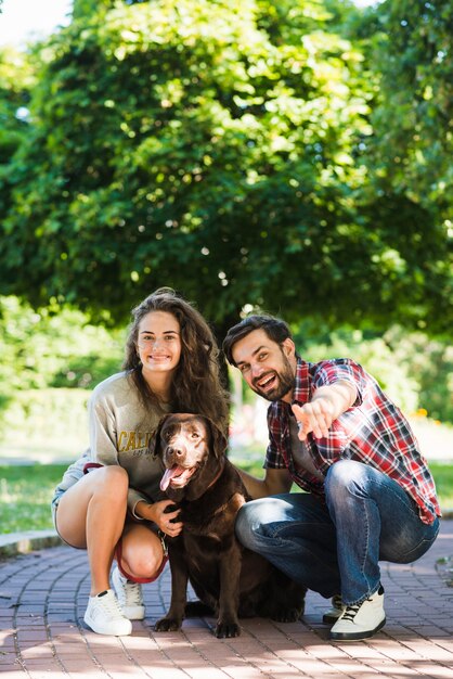 Feliz pareja joven con su perro en el jardín