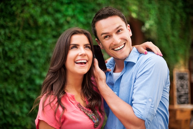 Foto gratuita feliz pareja joven con teléfono inteligente