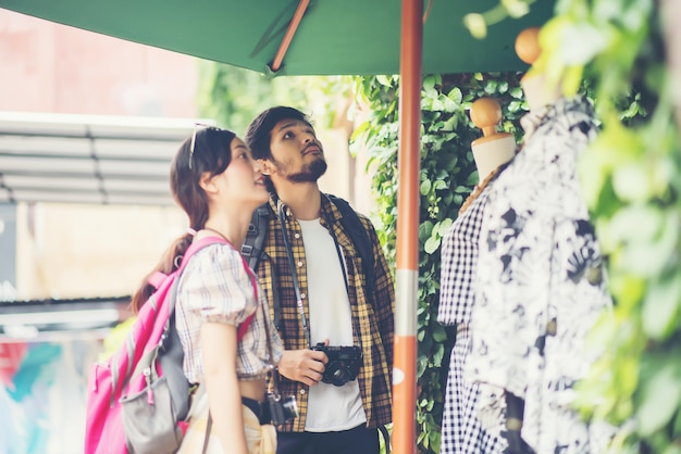 Feliz pareja de jóvenes mochileros pasear juntos por la calle