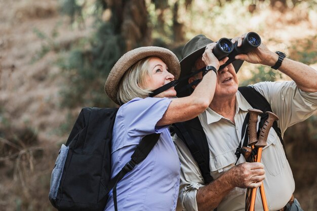Feliz pareja de jubilados disfrutando de la naturaleza en el bosque californiano
