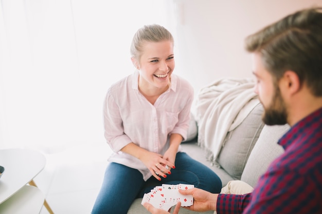 Feliz pareja jugando a las cartas en casa