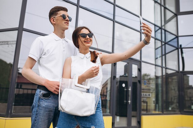 Feliz pareja juntos en la ciudad usando el teléfono