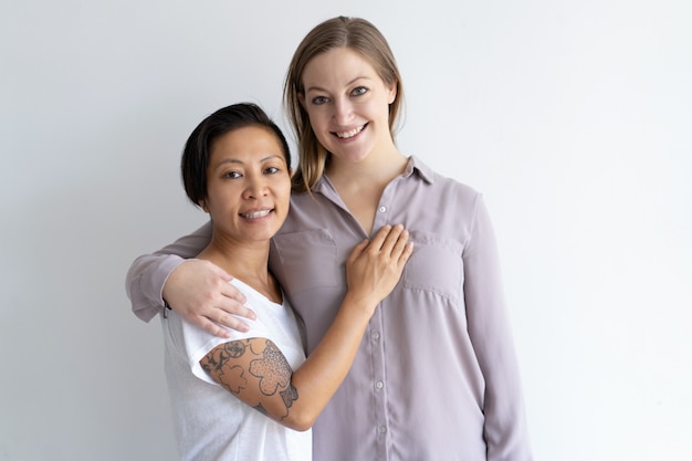 Feliz pareja de lesbianas multiétnica abrazando