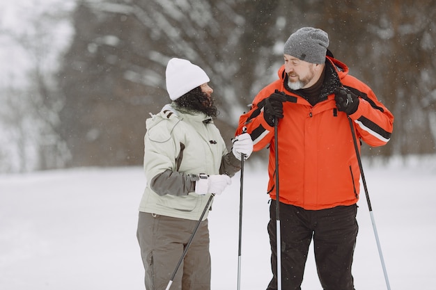 Feliz pareja madura en Winter Park. Personas activewear trekking en el bosque en el tiempo libre.