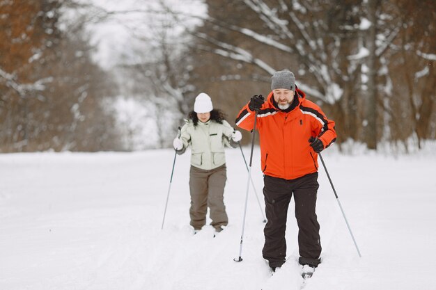 Feliz pareja madura en Winter Park. Personas activewear trekking en el bosque en el tiempo libre.