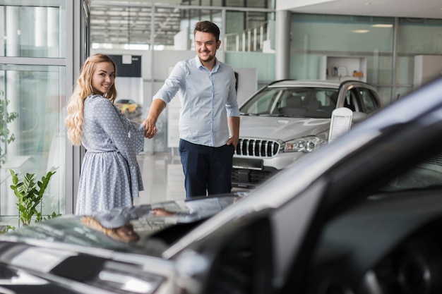 Feliz pareja mirando un auto