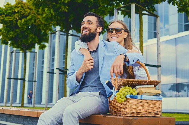 Una feliz pareja moderna en una cita hace un picnic en una ciudad.