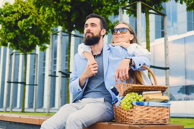 Una feliz pareja moderna en una cita hace un picnic en una ciudad.