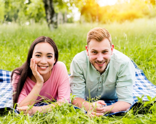 Feliz pareja multirracial posando en picnic