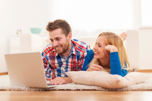 Feliz pareja navegando por la red en casa