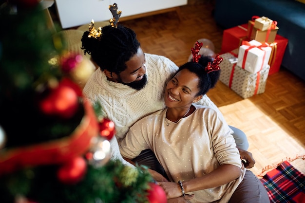 Feliz pareja negra enamorada disfrutando el día de Navidad en casa