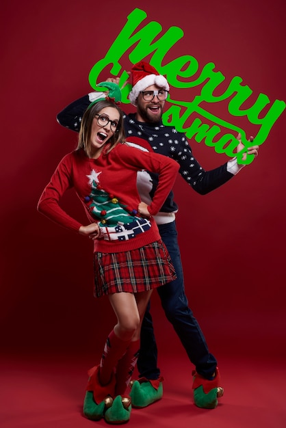 Feliz pareja nerd en ropa de Navidad aislado