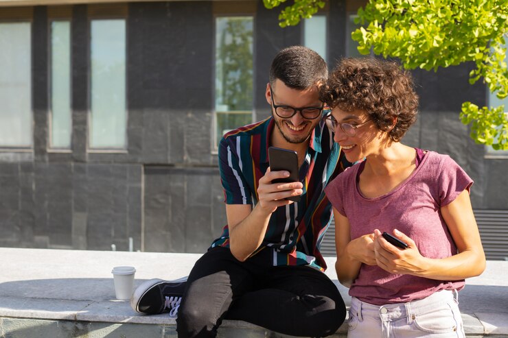 Foto gratuito feliz pareja nerd viendo contenido divertido en el teléfono