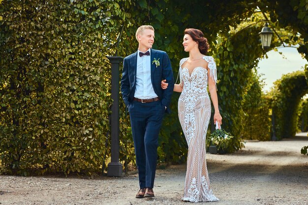 La feliz pareja de novios camina por el increíble jardín.