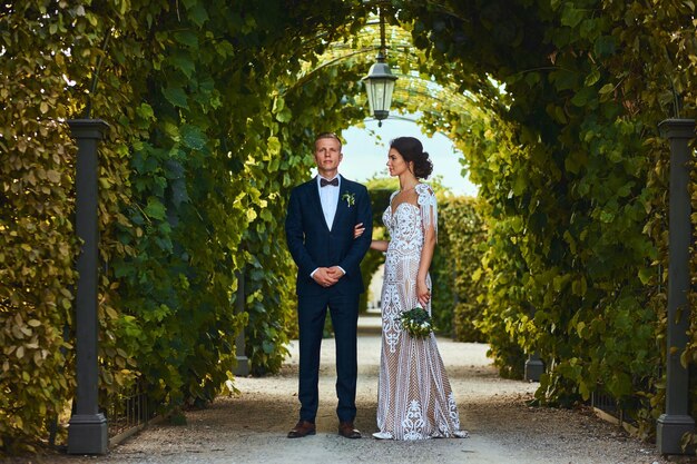 Feliz pareja de novios está caminando por el hermoso jardín.