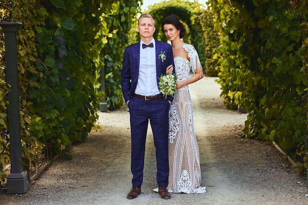 Feliz pareja de novios está caminando por el hermoso jardín.