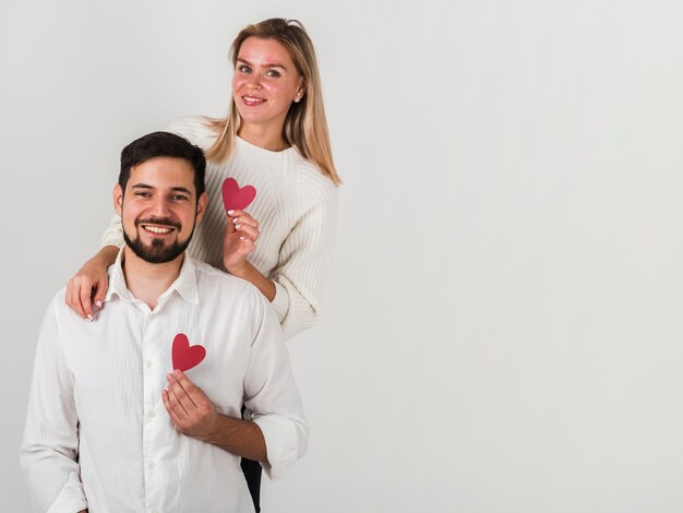 Feliz pareja posando con corazones