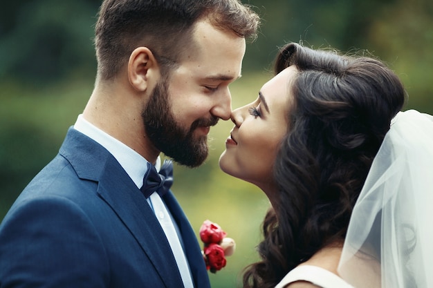 Feliz pareja de recién casados ​​mirando el uno al otro en un parque