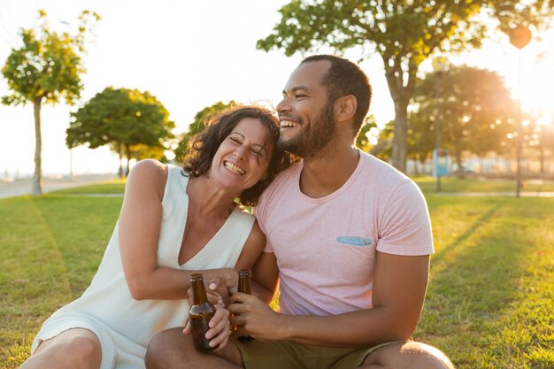 Feliz pareja relajada riendo y disfrutando del atardecer