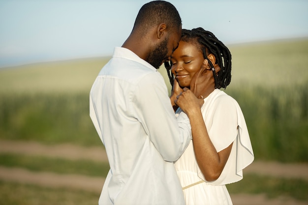 Feliz pareja romántica abrazándose en un campo de verano