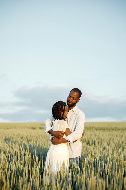 Feliz pareja romántica abrazándose en un campo de verano