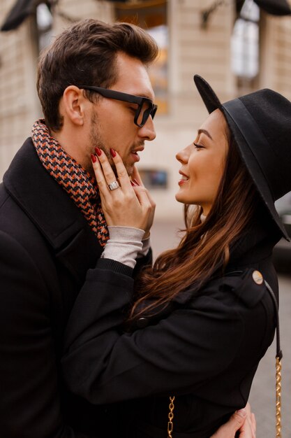 Feliz pareja romántica cara a cara, coqueteando y abrazándose en la calle mientras viajan juntos en su luna de miel por Europa.