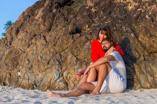 Feliz pareja romántica en la playa tropical al atardecer.