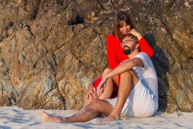 Feliz pareja romántica en la playa tropical al atardecer.