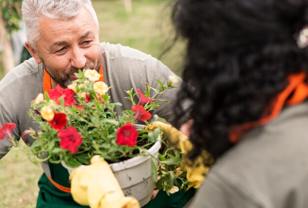 Foto gratuita feliz pareja senior con flores