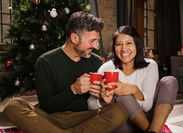 Feliz pareja senior de Navidad enoying bebidas calientes