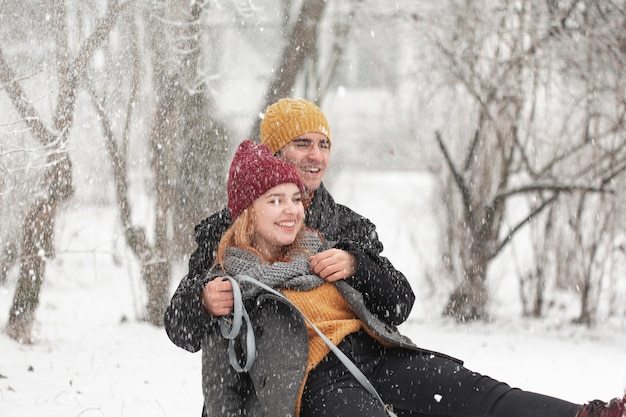 Foto gratuita feliz pareja sentada en la nieve