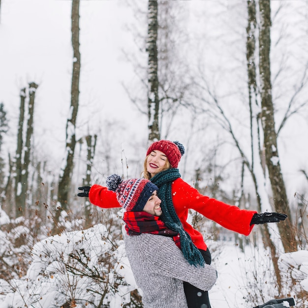 Feliz pareja soñando en bosque de invierno