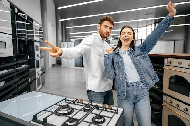 Feliz pareja sonriente acaba de comprar nuevos electrodomésticos en hipermercado