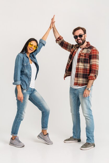 Feliz pareja sonriente dando equipo de cinco ganadores aislado en blanco studio