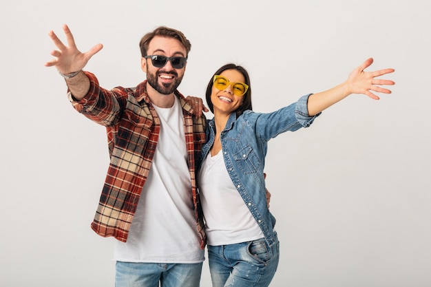 Foto gratuita feliz pareja sonriente tomados de la mano en la cámara aislada en blanco studio