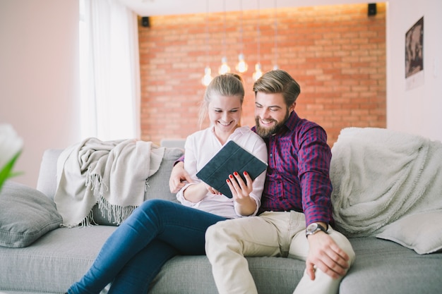 Feliz pareja sonriente usando tableta