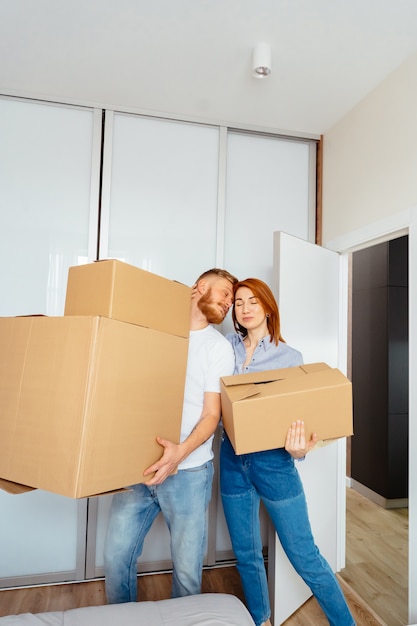 Feliz pareja sosteniendo cajas de cartón y mudarse a un nuevo lugar