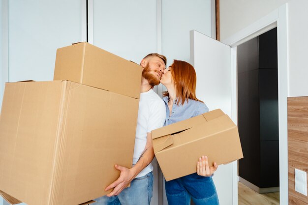 Feliz pareja sosteniendo cajas de cartón y mudarse a un nuevo lugar