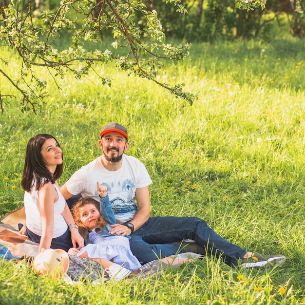 Foto gratuita feliz pareja con su hija disfrutando en el jardín