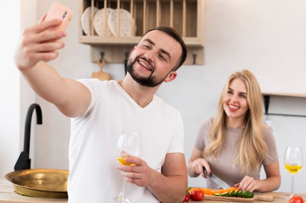 Feliz pareja tomando un selfie en la cocina