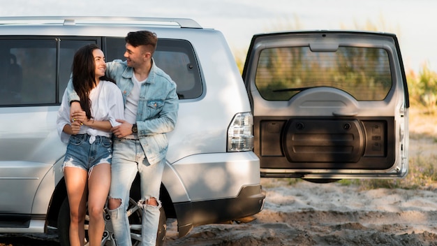 Feliz pareja de turistas y su coche